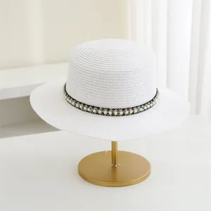 Zomer Franse elegante platte strohoed met parel geweven band voor zonbescherming op strand.