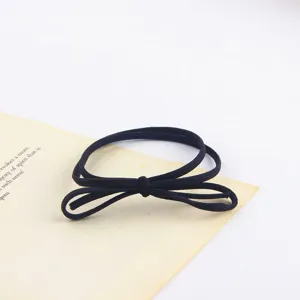 Detail view of a minimalist black elastic hair tie with a cute bow knot design for daily wear.