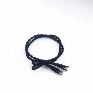 Detailed view of a stylish black elastic hair tie with metal ends for daily ponytails.