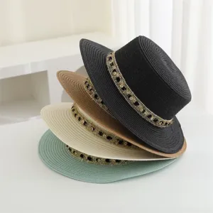 Vista detallada del elegante sombrero de paja plano con banda de estrás para el verano.