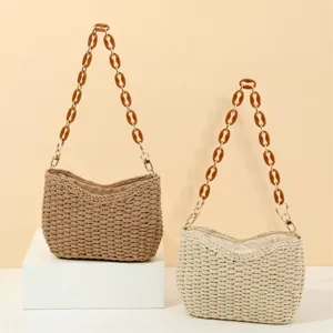 Detailed view of handmade woven straw shoulder bags featuring chic resin chain straps.