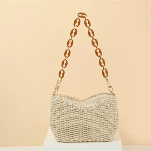Handmade crochet woven straw shoulder bag with stylish brown chain, perfect vacation detail.