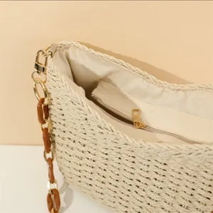 Crochet woven shoulder bag interior detail showing zipper pocket and chain strap.