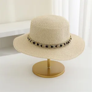 Elegante sombrero de paja beige con copa plana y cinta de tweed negro y oro para mujeres.