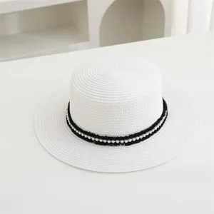 Primer plano de sombrero de paja blanco con cinta de perlas negras para mujeres vacaciones verano sol