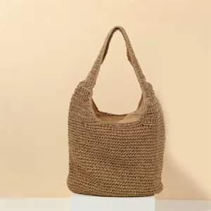 Detailed shot of the handmade crochet straw shoulder bag, showing close-up woven texture.