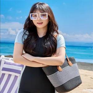 Stylish black and white striped straw tote bag for women, perfect for summer beach vacations.