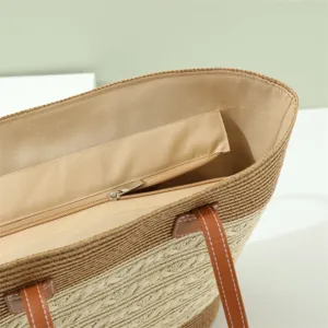 Vista dettagliata dell'interno della borsa di paglia estiva, con tessitura di qualità e tasca con zip.