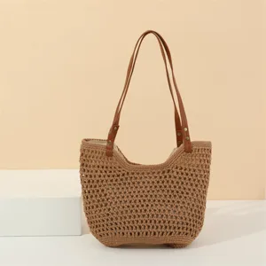 Detail view of the handmade crochet woven shoulder bag texture and brown leather strap.