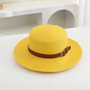 Detailaufnahme eines stilvollen Strohhutes mit flacher Oberseite und braunem Gürtel für den Sommer.