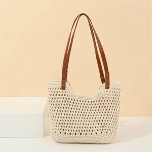 Detailed view of the beige crochet shoulder bag, showcasing intricate knit pattern and brown straps.