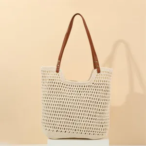 Handmade crochet woven underarm shoulder bag with brown leather strap for beach.
