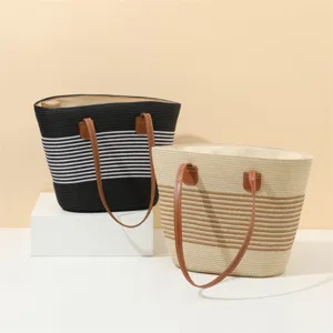 Detailed view of large capacity straw tote bag with stripe pattern and brown handles.