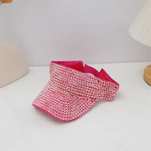 Primer plano de una visera solar brillante con pedrería rosa, sombrero de verano playa al aire libre.