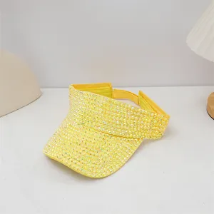 Primer plano detallado de una visera parasol amarilla brillante con pedrería brillante.