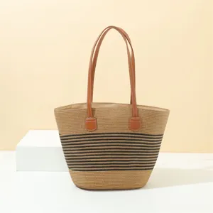 Summer straw tote bag with black stripes and brown leather handles for beach and daily casual use.