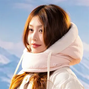 Close-up detail of winter warm pink hooded scarf face mask worn by model outdoors in snow.