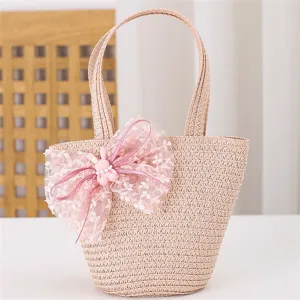 Detalle de bolso de paja rosa tejido, lindo lazo de encaje y encantador conejito para los niños.