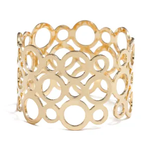 Gold metal napkin ring with modern hollow circle design, elegant table decor detail shot.