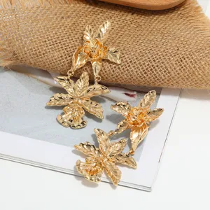 Nahaufnahme der goldenen Metallblumen-Ohrringe mit feiner Textur und tollem Detailblick.