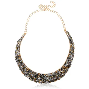Vista detallada del collar llamativo con piedras de cristal multicolores y cadena dorada.