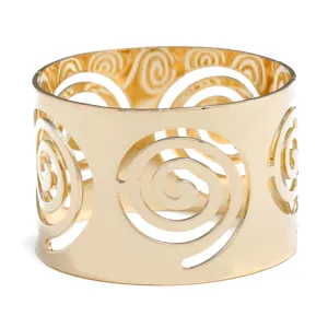 Detailed view of gold metal napkin ring with elegant cutout spiral design for table decor.