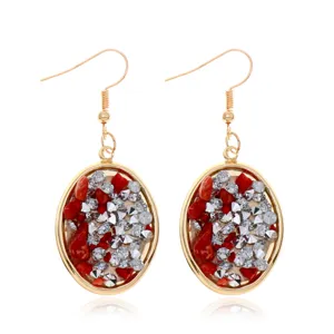 Vista detallada de pendientes colgantes dorados de moda con piedras trituradas y diamantes.