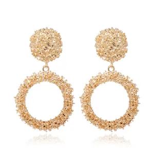 Pendientes statement texturizados dorados detalle de superficie metálica rugosa y elegante.