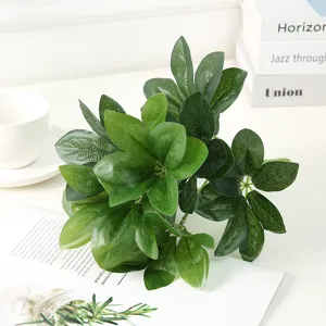 Close-up detail of artificial green foliage branch, realistic leaf texture and vivid color.