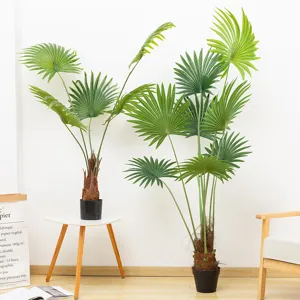 Vista dettagliata di palme a ventaglio artificiali in vaso in un ambiente nordico luminoso.