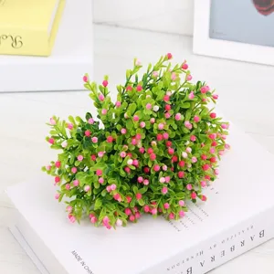 Artificial flower vine detail view, pink small flower buds with green leaves for home decoration.