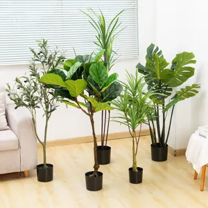 Primo piano di piante in vaso artificiali verdi con fogliame realistico per interni domestici.