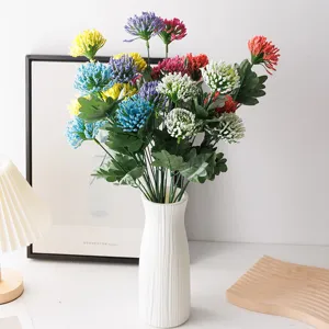 Detailed view of colorful artificial foam milan fruit flower arrangement in white ceramic vase.