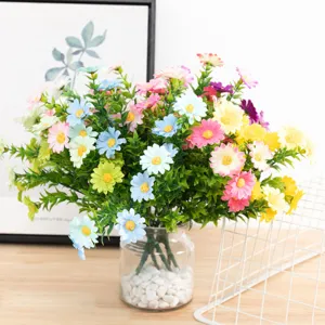 Artificial daisy flower bouquet in glass vase with white stones for home decor detail