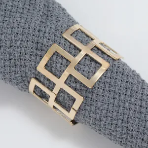 Gold metal geometric hollow napkin ring detail shot, elegant table decor napkin holder.