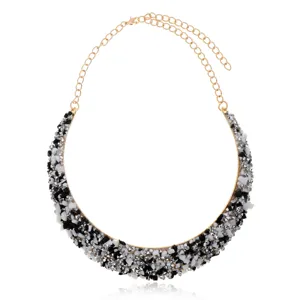Primer plano detallado de un collar llamativo con piedras incrustadas en blanco y negro.