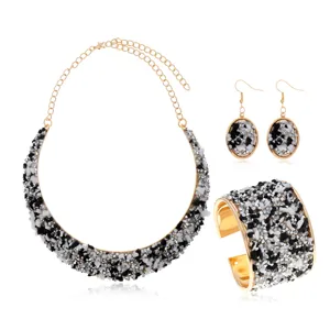 Vista detallada del elegante conjunto de joyas con piedras trituradas negras y blancas.