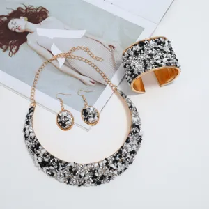 Primer plano del conjunto de joyas de piedras trituradas en blanco y negro, collar y pulsera.