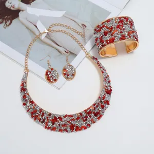 Conjunto de joyas de piedra triturada roja y plateada con collar, aretes y pulsera brazalete.