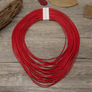 Vista detallada de un collar de cordón de cuero rojo multicapa con cierre de metal elegante.
