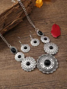 Close-up detail of vintage bohemian floral necklace and earrings jewelry set on wood.
