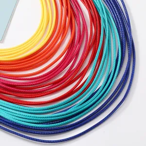 Vista detallada de cordones de cera trenzados coloridos, perfectos para joyería DIY.