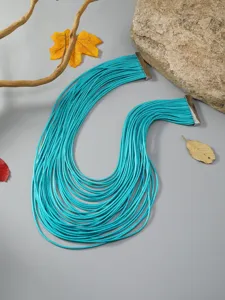 Primer plano del collar de cuerda turquesa de múltiples hilos con extremos metálicos detallados.