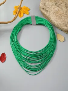 Detalle de collar gargantilla de cordón de cuero verde, joyería vintage para mujer.