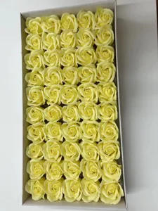 Gros plan détaillé de têtes de roses en savon jaune vif soigneusement rangées en boîte.