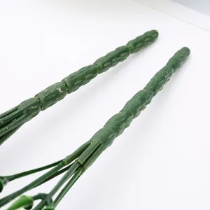 Primo piano dettaglio di steli di piante verdi artificiali in plastica per decorazioni.