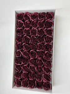 Vue détaillée de têtes de roses en savon parfumées rouge foncé rangées dans une boîte.