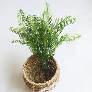 Pianta di felce artificiale in vaso di cesto intrecciato, vista dettagliata del fogliame verde.