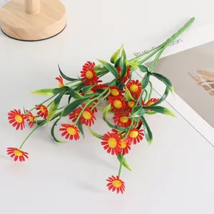 Close-up detail of artificial red and yellow daisy bouquet with green leaves for home decor.