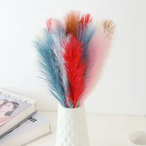 Detail shot of colorful artificial pampas grass reeds in white vase for home decor.